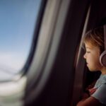 A child looking out an airplane, one of the results you get when searching how to get to Big Sky.