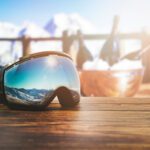 apres ski - goggles with mountains reflection on the restaurant table at ski resort